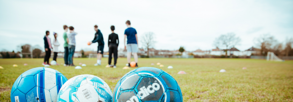 Holiday Camp FAQs 2 Children playing football at a Premier Education Holiday Camp
