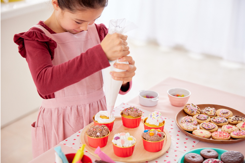 child decorating cupcakes